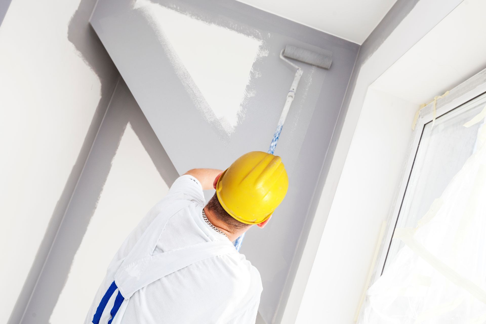 House painter paints a wall in a new home